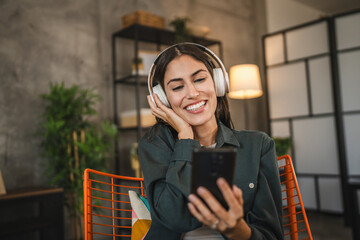 Adult woman with headphones listen to music on mobile phone