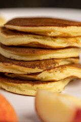 milk pancakes with butter and sliced peach slices