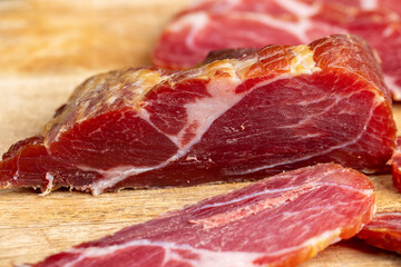 a piece of cured pork ham with thin layers of lard on the table