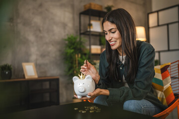 happy adult caucasian woman save money coins in the piggy bank