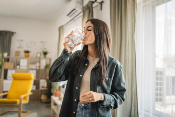 Portrait of adult young women stand and drink water at home