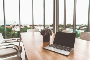Laptop computer with opened lid on table in office workspace. uds