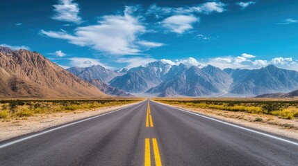 Naklejka premium Roadside scenery featuring a highway with tall mountains and a blue sky