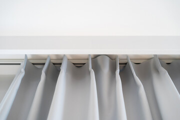 Gray pleated curtains hung on white rod