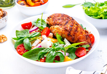 Summer grill salad with paprika and chicken meat, soft cheese, tomatoes, walnut, red onion and lettuce, white background, top view