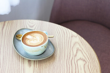 Hot latte art coffee cup on table in coffee shop
