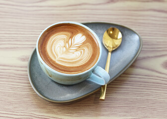 Hot latte art coffee cup on table in coffee shop