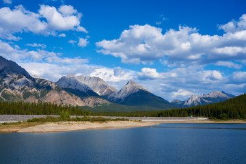 An incredible view of a natural mountain lake on a sunny summer day against the backdrop of the rocky mountains of Alberta in Canada.