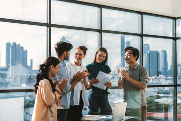 Portrait of diverse professional start up project team celebrate their project. Group of business people clapping hand, high five, cheer up for celebrating new product on table with laptop. Tracery.