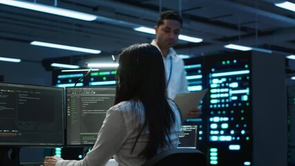 Team of researchers in data center monitoring security threats using PC, implementing cybersecurity measures. Teamworking colleagues ensuring compliance with regulations, camera A