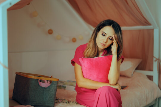 Sad Mom Sitting in a Kids Room By Herself . Mother feeling unhappy and depressed after difficult post-partum period 
