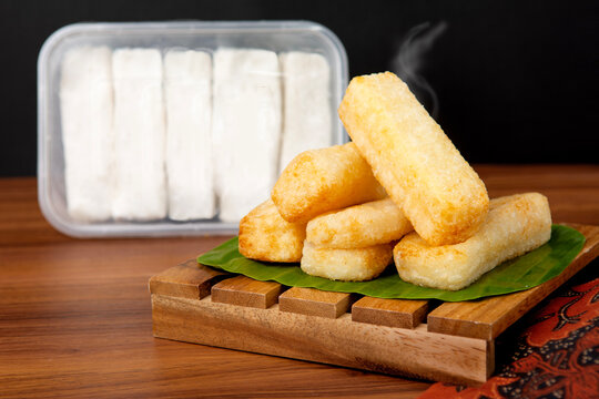 a wooden tray covered with banana leaves and filled with a pile of ulen or uli food with a cup of coffee and a fork
