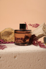 Amber Glass Bottle on Stone Block with Purple Leaves for Organic Skincare or Fragrance Mockup