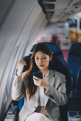 Asian woman sitting in a seat in airplane and looking out the window going on a trip vacation travel concept.Capture the allure of wanderlust with this stunning image