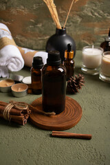 Amber Glass Bottle with Candles and Cinnamon on Rustic Green Background for Skincare and Aromatherapy Mockup