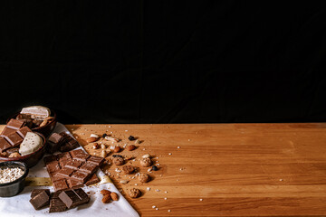 Chocolate chip cookies, dark and white chocolate bar, small bowl of oatmeal and nuts. International Chocolate Day. Copy space.