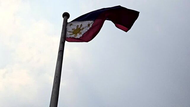 Philippine flag waving in the wind against the sky