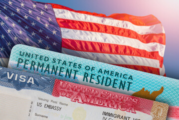 VISA United States of America. Green Card US Permanent resident. Work and Travel ID documents. US Immigrant. Visa for Immigration. Embassy USA. Visa in passport. American flag on background © Anna