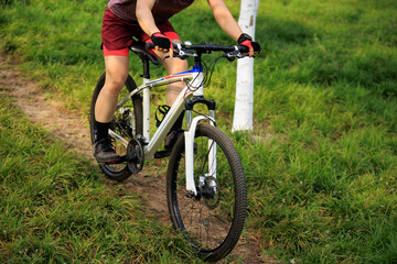 Fototapeta premium Woman biker mountain biking on mountain forest trail