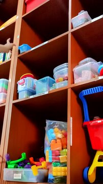 A therapist is selecting toys in the toy room, which will be used during a therapy session.