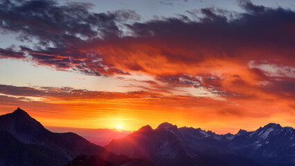 Fototapeta premium Vibrant Sunset Over Mountain Range with Dramatic Lighting and Rich Color