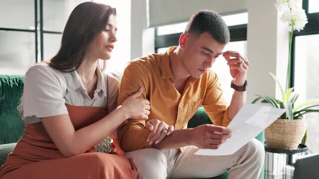 Support, couple and sad with document in home, console and empathy with caring partner in marriage. Sofa, woman and man with stress for bills, financial mistake and wife for emotional assurance
