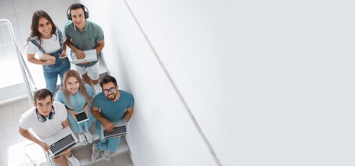 Students with modern devices on stairs in university, top view