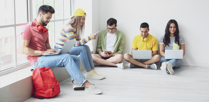 Students with modern devices studying online indoors