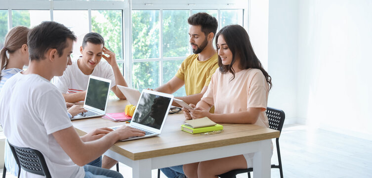 Students with modern devices studying online indoors