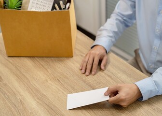 sending resignation letter to boss and Holding Stuff Resign Depress or carrying cardboard box by desk in office