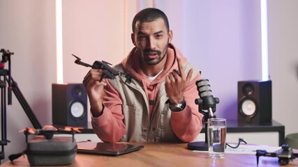 Talking, podcast and product of man for promotion, sharing drone and streaming show for broadcast. Face, helicopter and microphone with male influencer for content creation, advice or how to tutorial