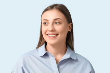 Beautiful woman smiling on blue background, closeup