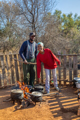 african street vendors on outdoors kitchen cooking traditional food in cauldron by the side of the...