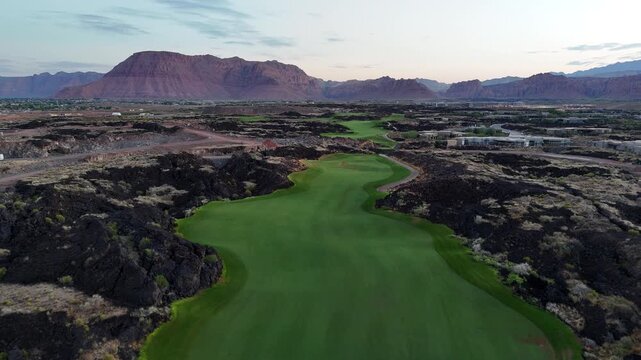 Aerial footage of the fairway at Black Desert Golf Course in Ivins, Utah. The video captures the lush green fairway surrounded by rocky desert terrain with red mountains in the background. Ivins, Utah