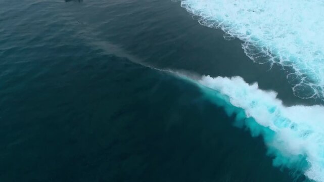 Drone turns quickly to follow crashing wave erupting into whitewash at Cloudbreak Fiji
