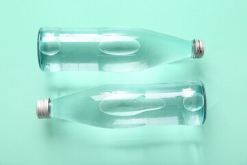 Bottles of clean water on green background