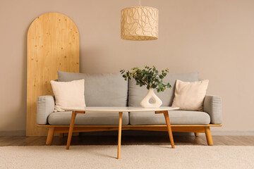 Interior of living room with eucalyptus in vase and sofa