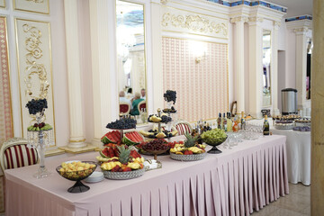 A beautiful buffet table with a variety of fruits and drinks.
