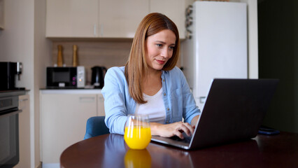 Woman doing online tasks on her laptop at home