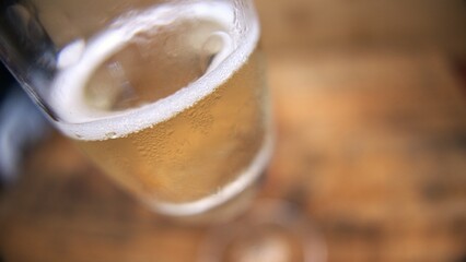 A close-up shot of a sparkling wine flute on the table. Champagne bubbles in a flute. A glass of sparkling wine in details. 