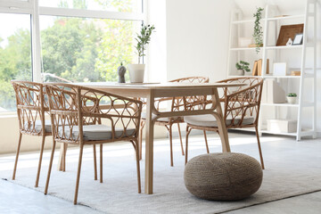 Interior of dining room with table, shelf unit and pouf