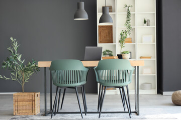Interior of dining room with table, shelf unit and plants