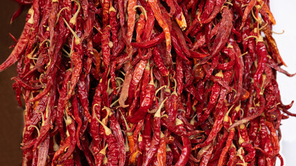 Fototapeta premium dried hot peppers strung on strings. Close up pepper background