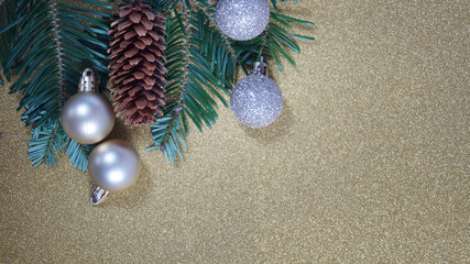 Christmas decorations and fir branches on a golden background. Frame made of pine branches and Christmas decorations.