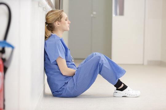 upset nurse sitting on floor