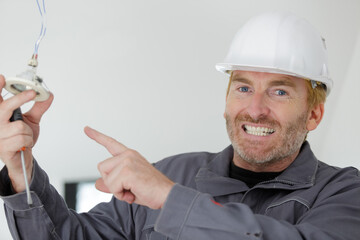 electrician pointing at spot light