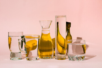 Bananas behind glass vessels filled with water. Distorted reflection.