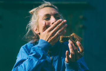 Healthy Kitchen - laughing woman eats vegan brownie to the camera