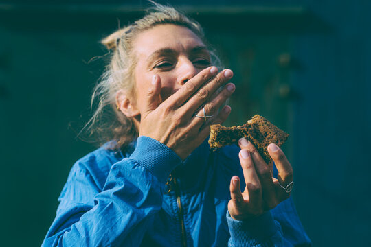 Healthy Kitchen - laughing woman eats vegan brownie to the camera