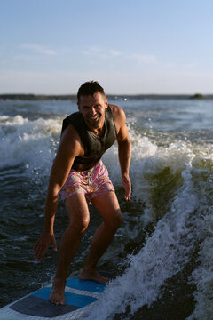 Man wakesurfing behind wakeboard boat.